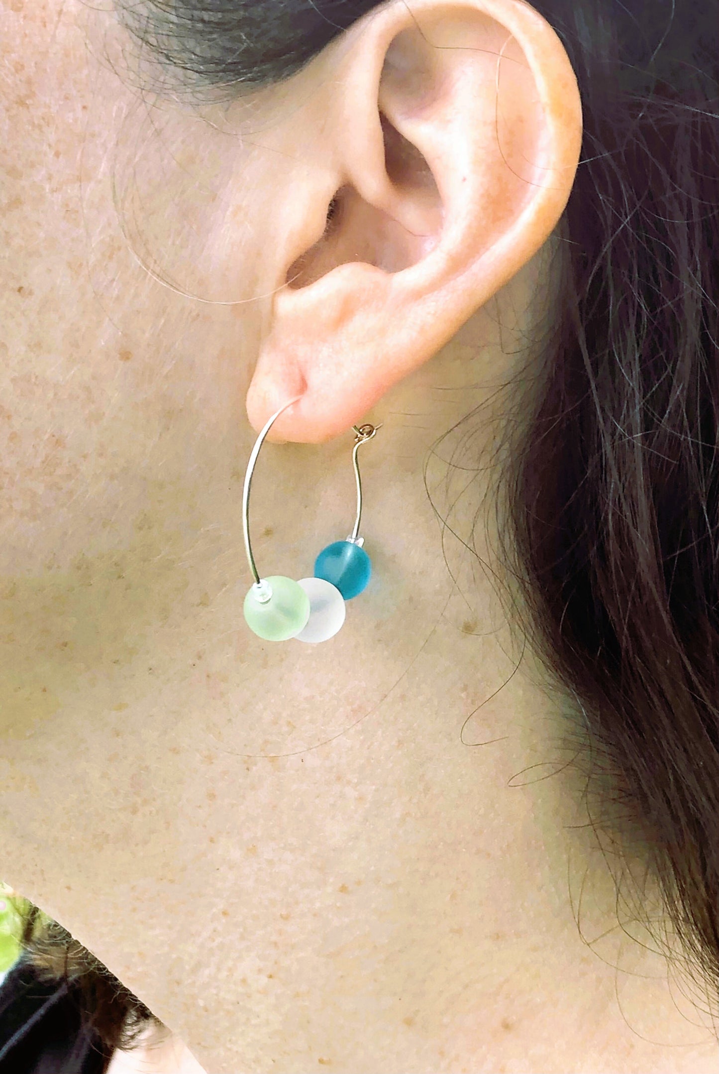 Silver hoop earrings with glass bead detail