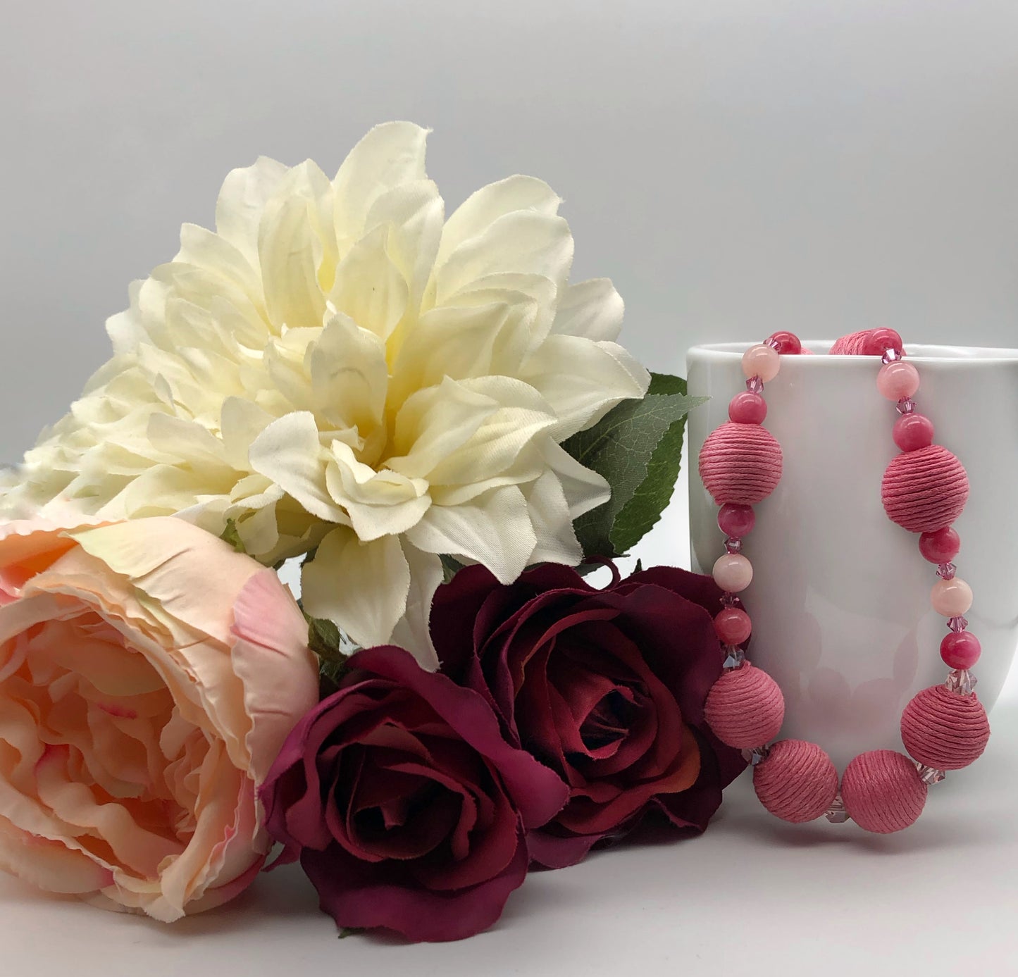Pink rhodonite, crystal, and cotton beaded necklace