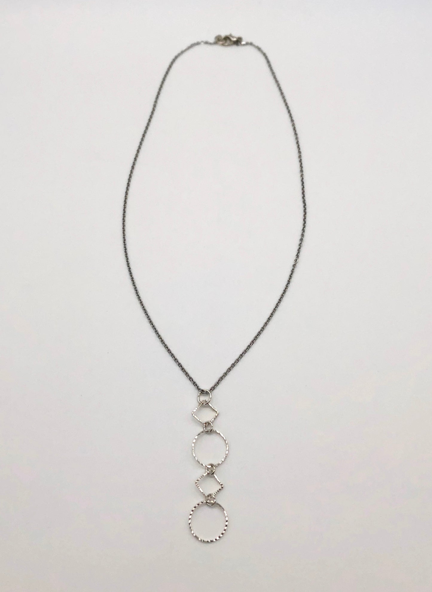 Silver-plated laser cut circle and diamond shape pendant on chain necklace
