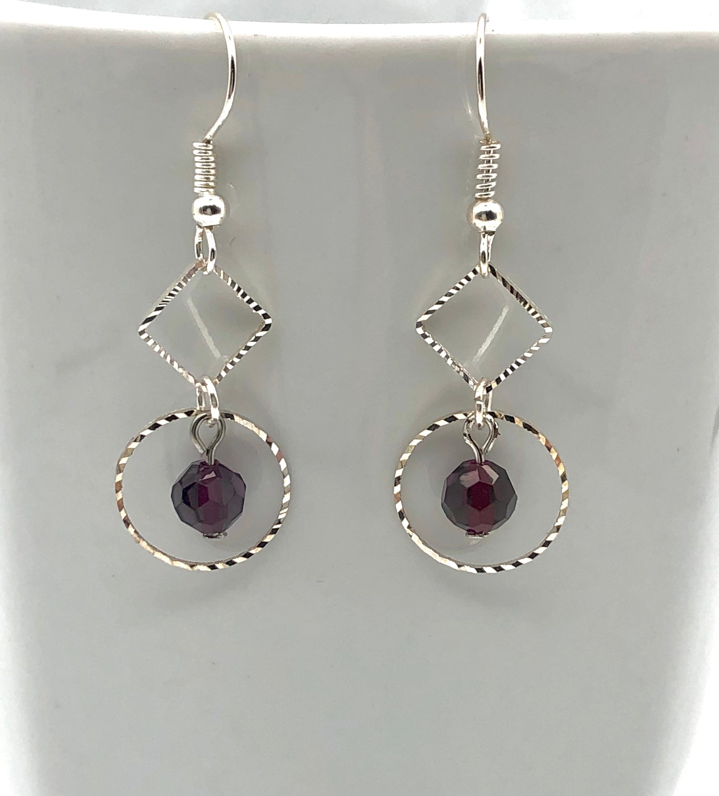 Purple faceted bead with diamond and circle shaped cutout dangly earrings