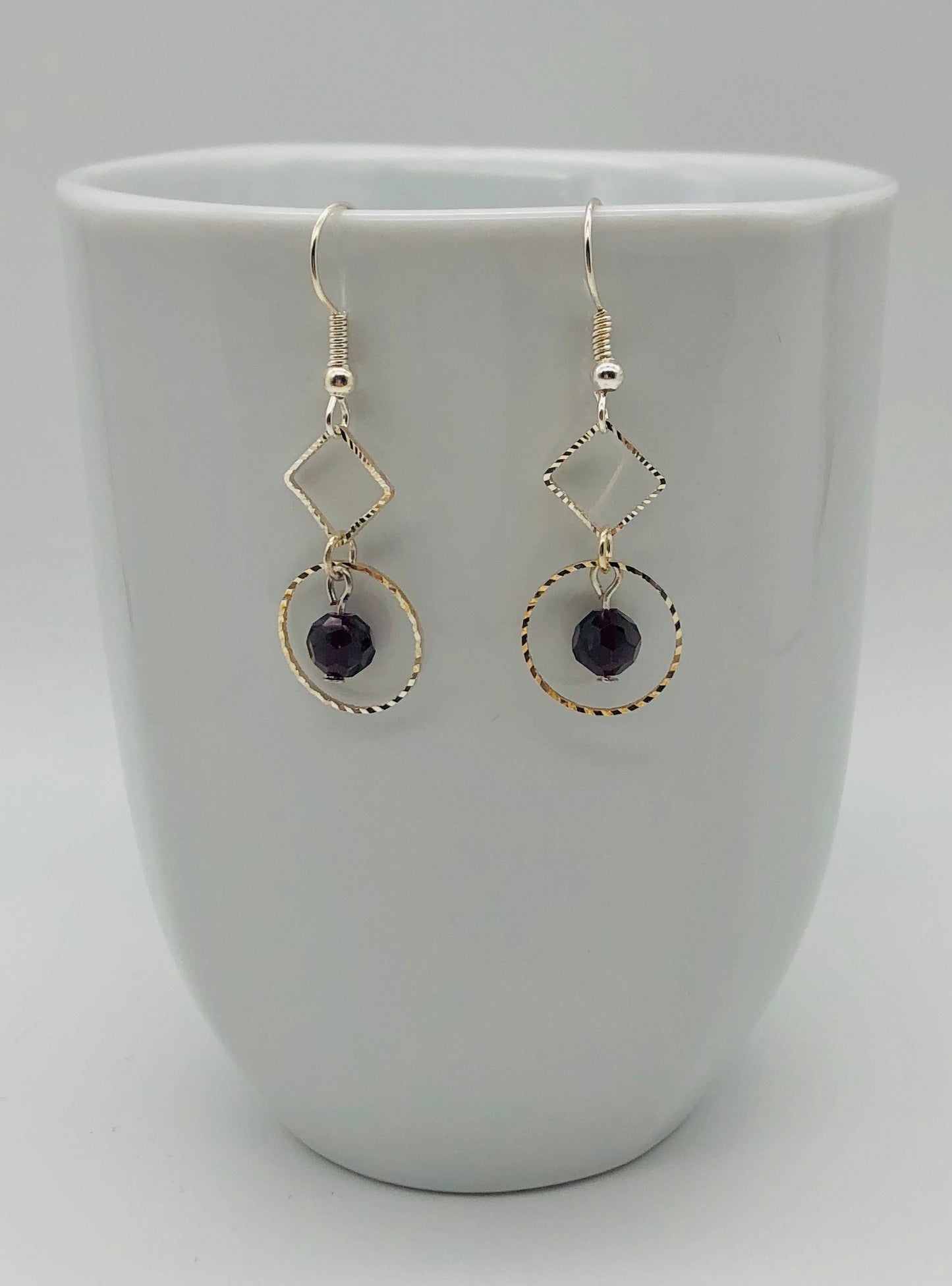 Purple faceted bead with diamond and circle shaped cutout dangly earrings
