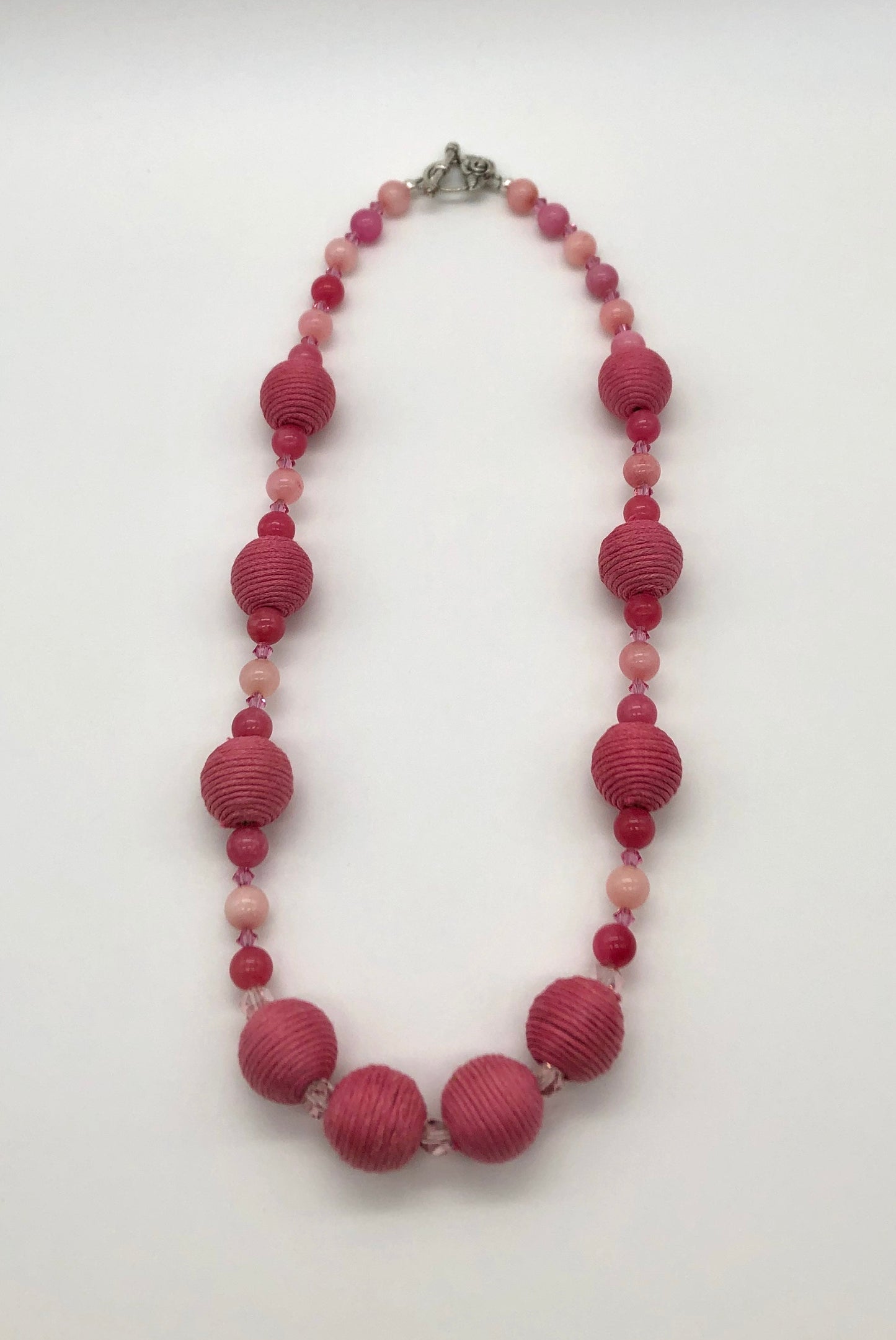 Pink rhodonite, crystal, and cotton beaded necklace