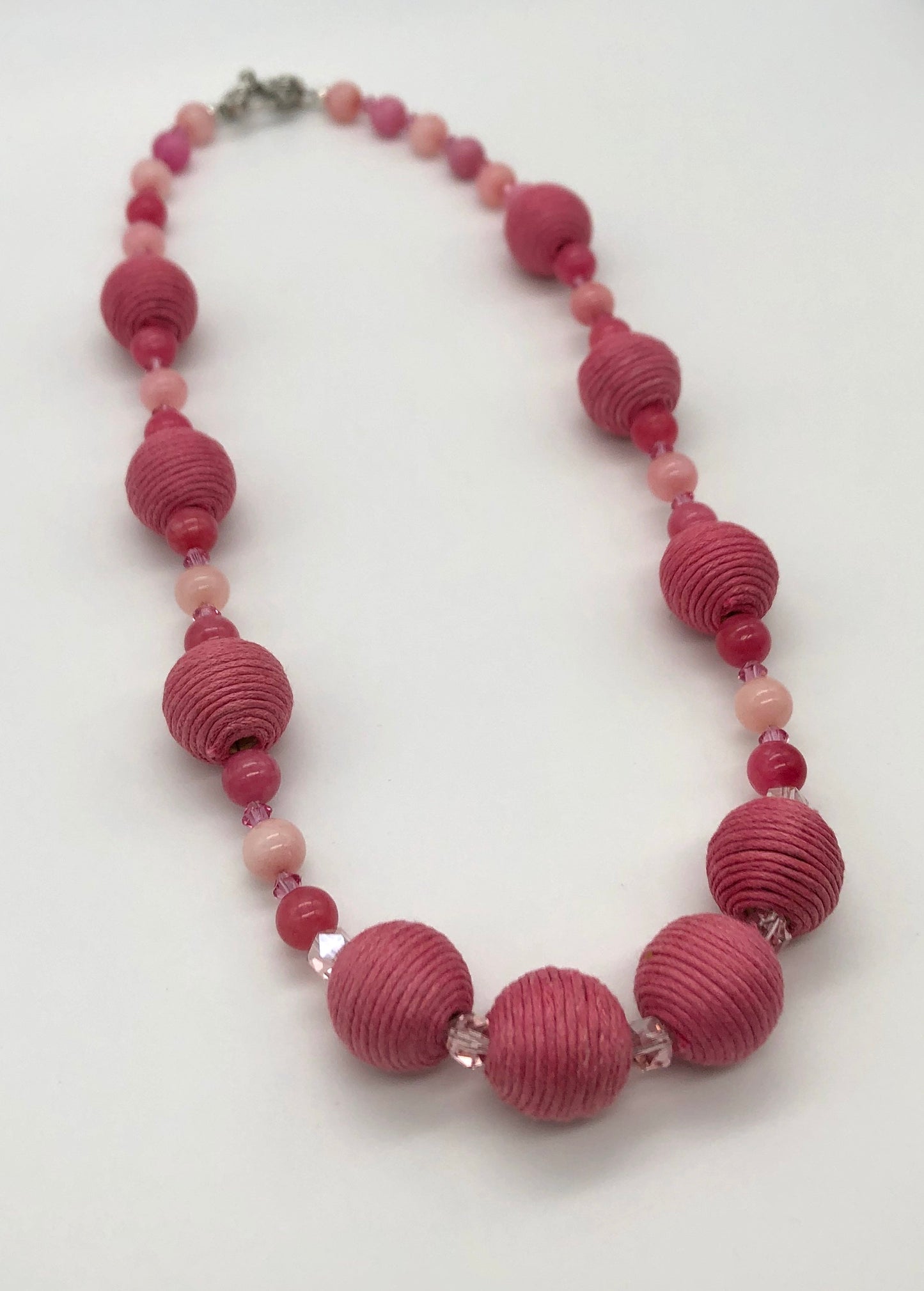 Pink rhodonite, crystal, and cotton beaded necklace